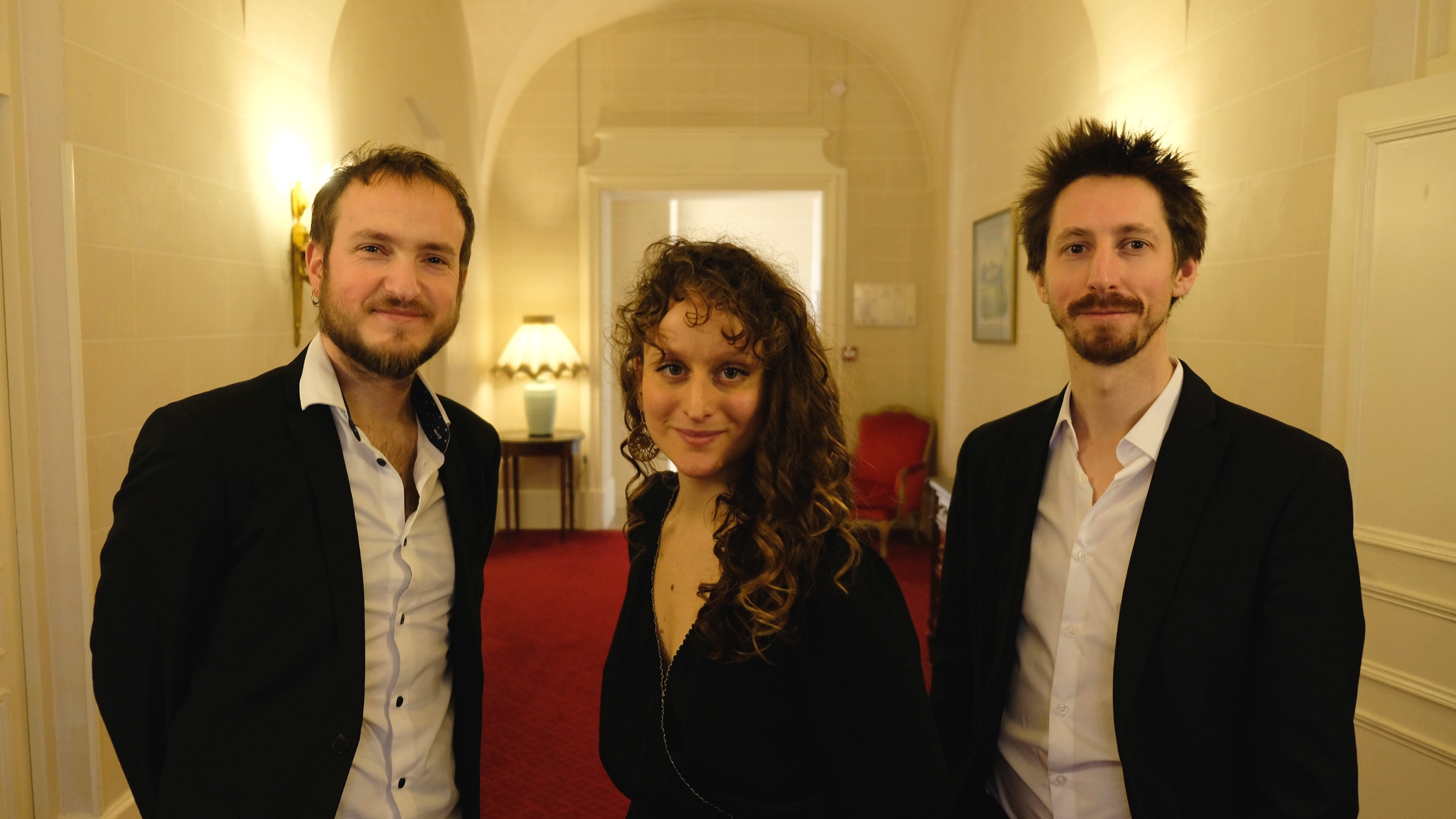 Les trois musiciens de Léa Caraballe Trio dans un salon aux lumières dorées